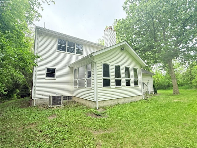 9343 E Bayshore Rd, Marblehead, OH 43440 - back of property featuring a chimney, cooling unit, and a lawn