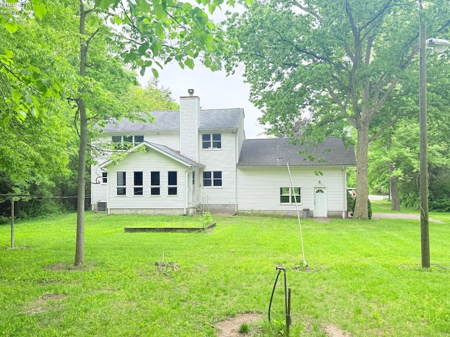 9343 E Bayshore Rd, Marblehead, OH 43440 - back of property featuring a yard, a chimney, a shingled roof, and cooling unit
