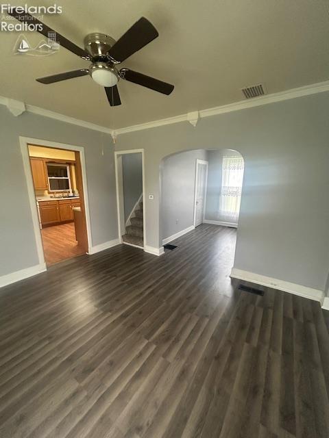 201 Heter St, Bellevue, OH 44811 - spare room with arched walkways, crown molding, baseboards, a ceiling fan, and stairway