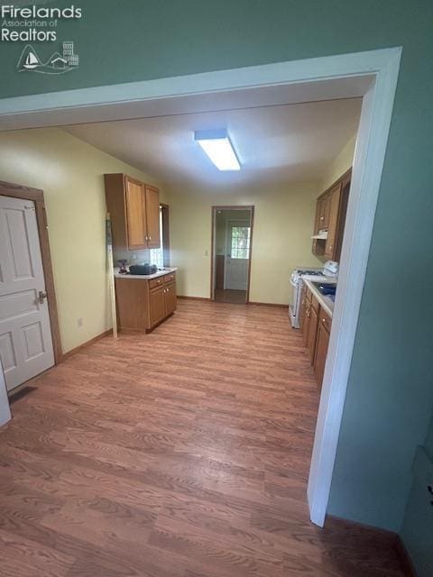 201 Heter St, Bellevue, OH 44811 - kitchen with brown cabinets, light wood-style floors, white stove, light countertops, and baseboards