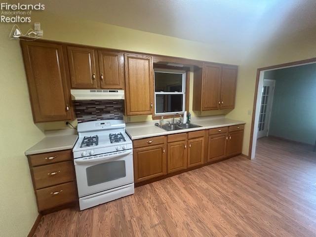201 Heter St, Bellevue, OH 44811 - kitchen featuring gas range gas stove, under cabinet range hood, a sink, light wood-type flooring, and light countertops