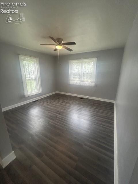 201 Heter St, Bellevue, OH 44811 - spare room with healthy amount of natural light, baseboards, a ceiling fan, and dark wood-style flooring
