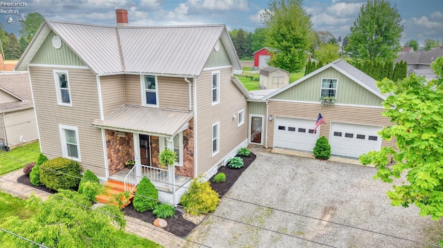134 Hobson St, Bellevue, OH 44811 - view of front of house with covered porch, a chimney, a garage, metal roof, and gravel driveway