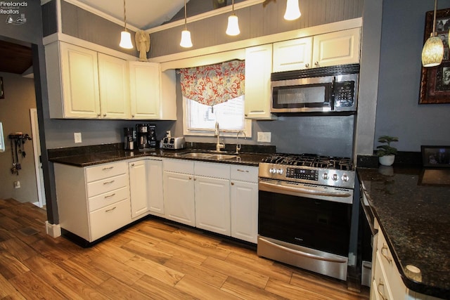 134 Hobson St, Bellevue, OH 44811 - kitchen featuring gas stove, a sink, light wood-style flooring, white cabinets, and vaulted ceiling