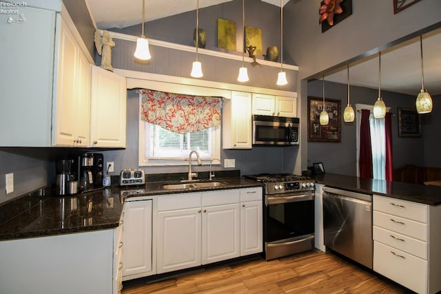 134 Hobson St, Bellevue, OH 44811 - kitchen with appliances with stainless steel finishes, a sink, white cabinets, a peninsula, and light wood-style flooring