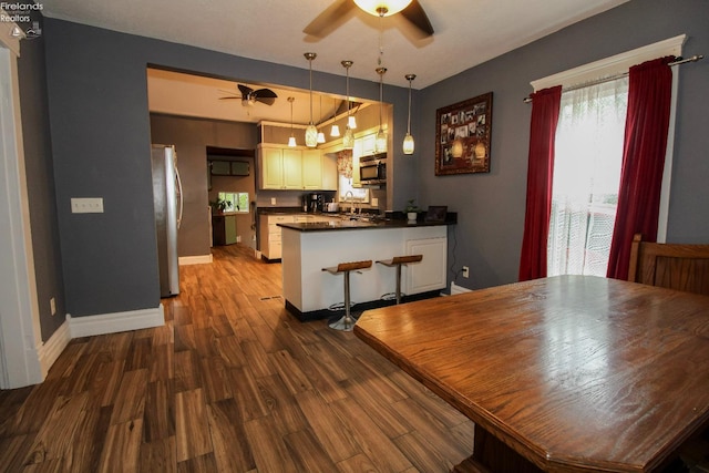 134 Hobson St, Bellevue, OH 44811 - dining space featuring a ceiling fan, wood finished floors, and baseboards