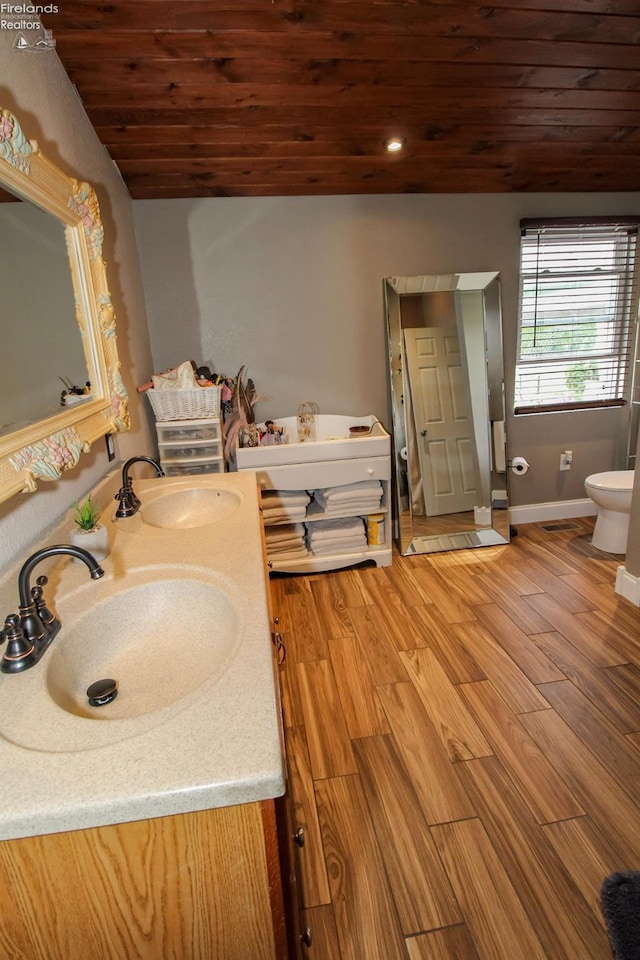 134 Hobson St, Bellevue, OH 44811 - bathroom with double vanity, wood ceiling, wood finished floors, baseboards, and a bathtub