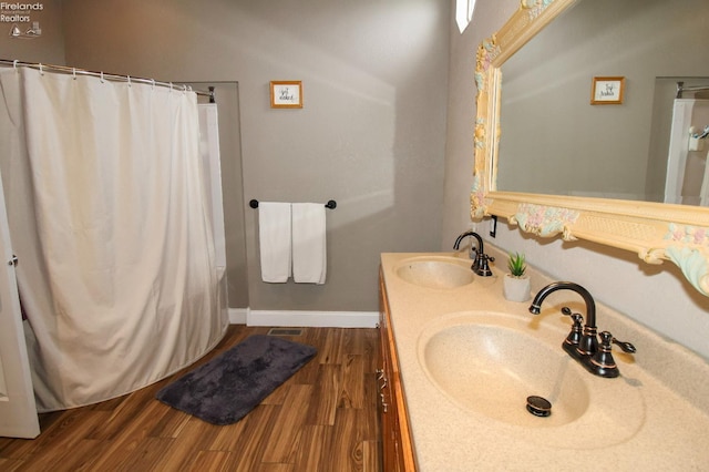 134 Hobson St, Bellevue, OH 44811 - bathroom with wood finished floors, double vanity, baseboards, and a shower with curtain