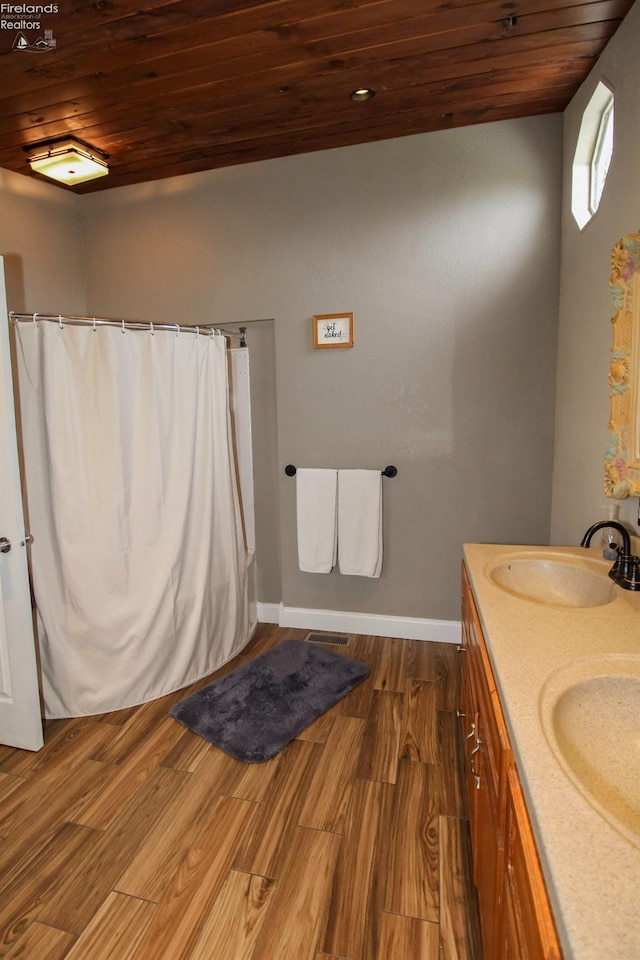 134 Hobson St, Bellevue, OH 44811 - full bath featuring wooden ceiling, wood finished floors, baseboards, double vanity, and a shower with curtain