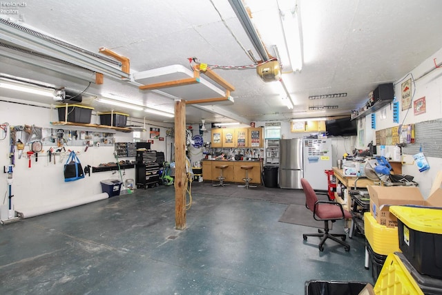 134 Hobson St, Bellevue, OH 44811 - garage with a workshop area, freestanding refrigerator, and a garage door opener