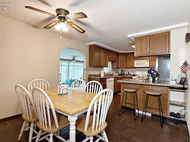 31 Mohawk St, Tiffin, OH 44883 - dining space featuring ceiling fan, arched walkways, and baseboards