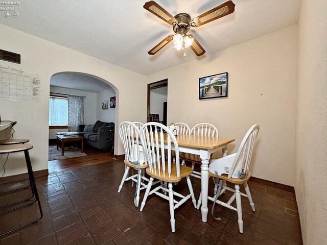 31 Mohawk St, Tiffin, OH 44883 - dining space featuring arched walkways, ceiling fan, brick patterned floors, and baseboards