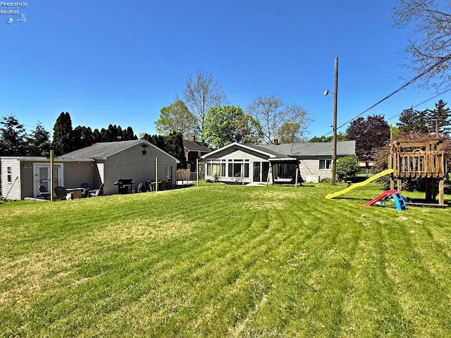 31 Mohawk St, Tiffin, OH 44883 - view of green lawn with a playground and a sunroom