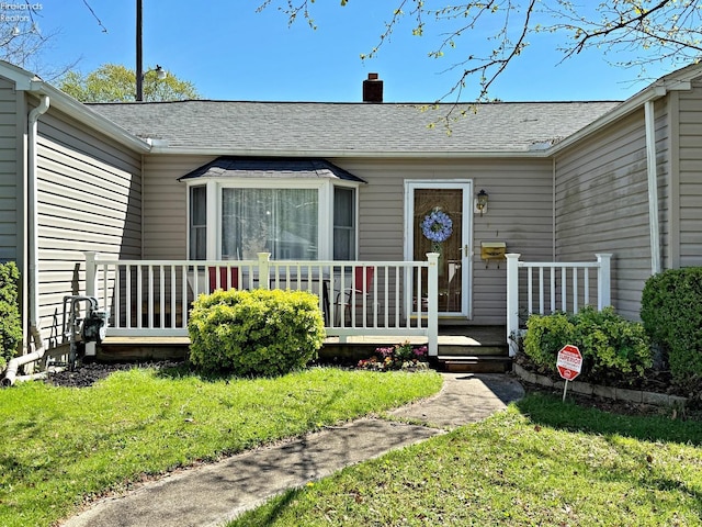31 Mohawk St, Tiffin, OH 44883 - view of exterior entry with a chimney, a lawn, and a shingled roof