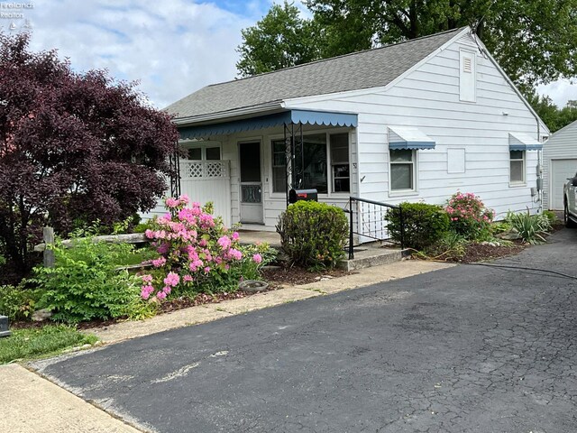 52 Prospect St, New London, OH 44851 - bungalow-style house featuring a shingled roof and asphalt driveway