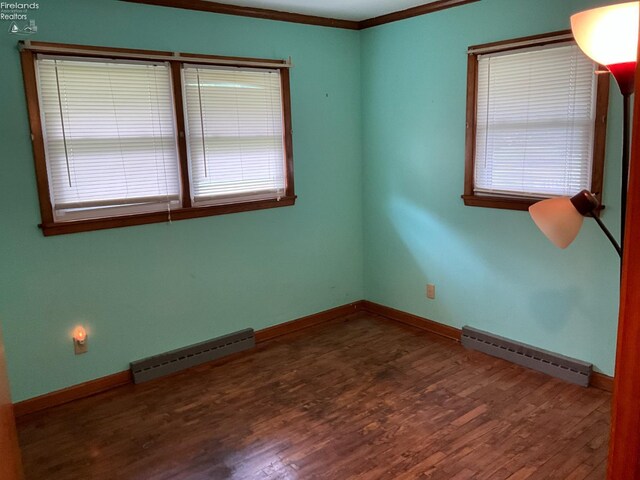 52 Prospect St, New London, OH 44851 - empty room with a baseboard radiator, wood finished floors, ornamental molding, baseboards, and plenty of natural light