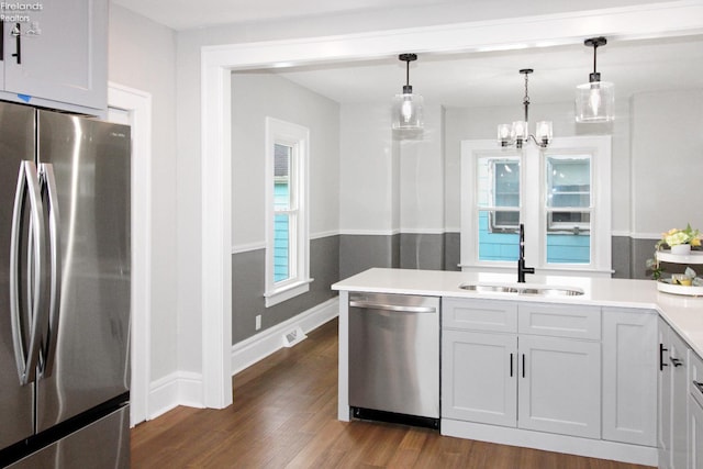 713 Madison St, Port Clinton, OH 43452 - kitchen with appliances with stainless steel finishes, a sink, a chandelier, dark wood finished floors, and light countertops