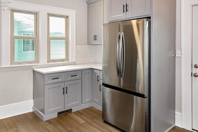 713 Madison St, Port Clinton, OH 43452 - kitchen with freestanding refrigerator, light wood-style floors, gray cabinetry, light countertops, and tasteful backsplash