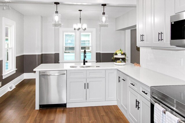 713 Madison St, Port Clinton, OH 43452 - kitchen featuring appliances with stainless steel finishes, a sink, dark wood-style flooring, light countertops, and a chandelier