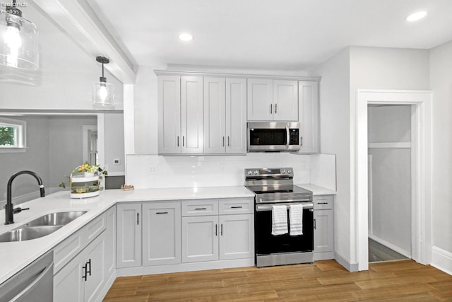 713 Madison St, Port Clinton, OH 43452 - kitchen with stainless steel appliances, a sink, backsplash, light countertops, and light wood-style flooring