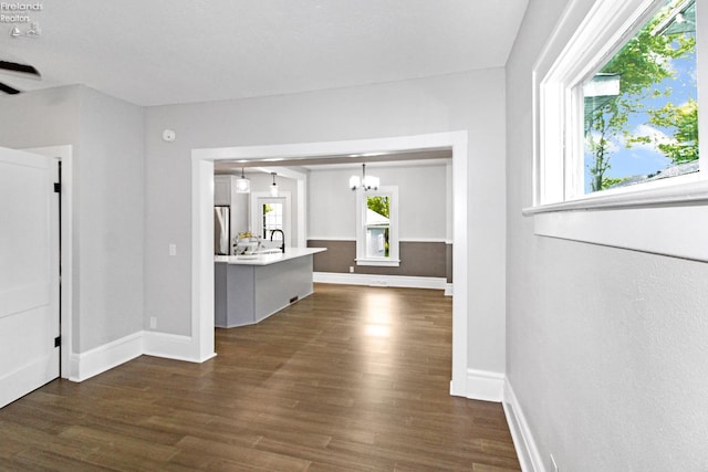 713 Madison St, Port Clinton, OH 43452 - unfurnished living room featuring a chandelier, dark wood finished floors, baseboards, and a sink