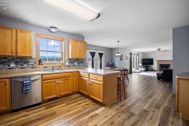 4936 Gibbs Rd, Norwalk, OH 44857 - kitchen featuring stainless steel dishwasher, a sink, a peninsula, backsplash, and open floor plan