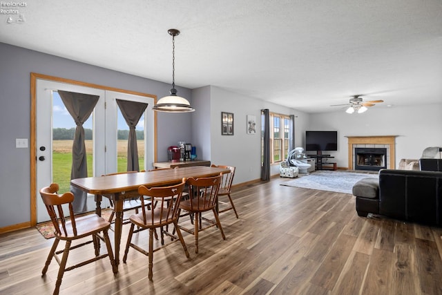4936 Gibbs Rd, Norwalk, OH 44857 - dining area with wood finished floors, ceiling fan, baseboards, and a tiled fireplace