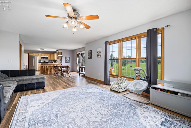 4936 Gibbs Rd, Norwalk, OH 44857 - living room featuring ceiling fan, wood finished floors, and baseboards