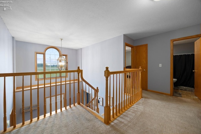 4936 Gibbs Rd, Norwalk, OH 44857 - corridor featuring an upstairs landing, carpet floors, a chandelier, a textured ceiling, and baseboards