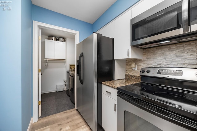 4370 Marin Woods Dr Unit D, Port Clinton, OH 43452 - kitchen with stainless steel appliances, tasteful backsplash, white cabinetry, and light wood-type flooring