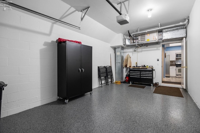 4370 Marin Woods Dr Unit D, Port Clinton, OH 43452 - garage with a garage door opener, freestanding refrigerator, and concrete block wall
