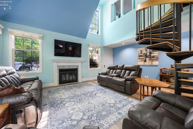 4370 Marin Woods Dr Unit D, Port Clinton, OH 43452 - living room with baseboards, a glass covered fireplace, a towering ceiling, and wood finished floors