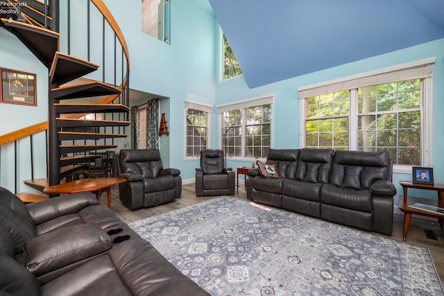 4370 Marin Woods Dr Unit D, Port Clinton, OH 43452 - living room featuring wood finished floors, high vaulted ceiling, stairway, and baseboards