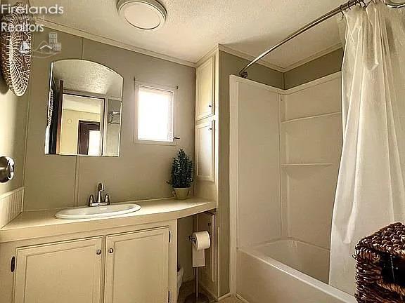 3575 NE Catawba Rd Unit 5, Port Clinton, OH 43452 - full bathroom featuring vanity, shower / tub combo with curtain, crown molding, toilet, and a textured ceiling