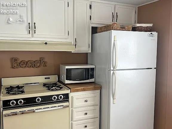 3575 NE Catawba Rd Unit 5, Port Clinton, OH 43452 - kitchen featuring white appliances, white cabinets, and dark countertops