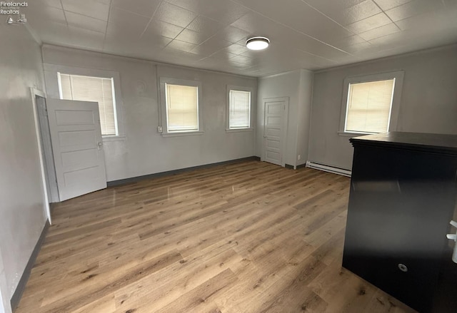 118 E 5th St, Port Clinton, OH 43452 - unfurnished bedroom with a baseboard radiator, wood finished floors, and baseboards