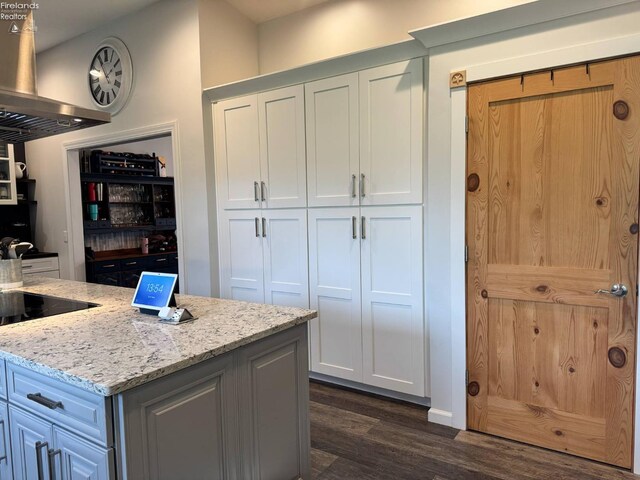 505 E Stoneplace Dr, Sandusky, OH 44870 - kitchen with dark wood-style flooring, light stone counters, white cabinetry, and wall chimney exhaust hood