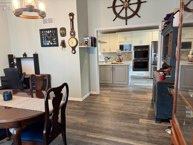 505 E Stoneplace Dr, Sandusky, OH 44870 - dining room featuring a chandelier, dark wood-style floors, and baseboards
