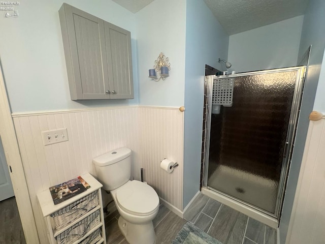 505 E Stoneplace Dr, Sandusky, OH 44870 - bathroom featuring a shower stall, wood finish floors, toilet, and wainscoting