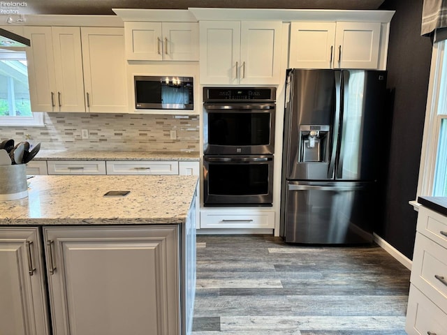 505 E Stoneplace Dr, Sandusky, OH 44870 - kitchen with appliances with stainless steel finishes, wood finished floors, white cabinetry, tasteful backsplash, and light stone countertops