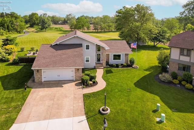 505 E Stoneplace Dr, Sandusky, OH 44870 - mid-century modern home featuring driveway, brick siding, a front yard, view of wooded area, and roof with shingles