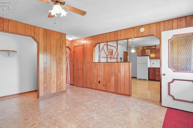 1450 Claus Rd, Vermilion, OH 44089 - unfurnished living room with wooden walls, a ceiling fan, and light floors