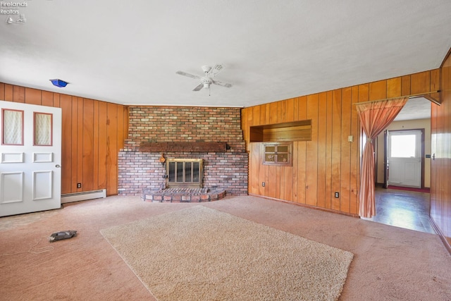 1450 Claus Rd, Vermilion, OH 44089 - unfurnished living room featuring carpet flooring, baseboard heating, ceiling fan, and wood walls