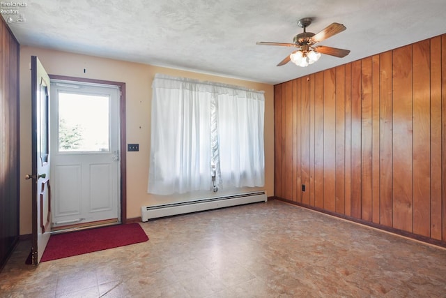 1450 Claus Rd, Vermilion, OH 44089 - entryway featuring baseboard heating, wood walls, a ceiling fan, and tile patterned floors
