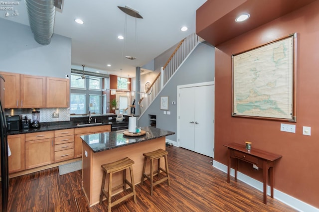 1402 Newman Ave, Lakewood, OH 44107 - kitchen with dark wood finished floors, a center island, a kitchen bar, recessed lighting, and pendant lighting
