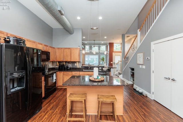 1402 Newman Ave, Lakewood, OH 44107 - kitchen with black appliances, dark wood finished floors, a center island, a kitchen breakfast bar, and recessed lighting