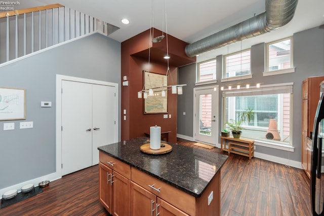 1402 Newman Ave, Lakewood, OH 44107 - kitchen with high vaulted ceiling, dark wood-style flooring, brown cabinets, dark stone counters, and a center island