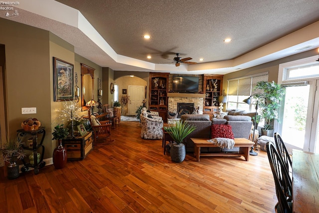 3826 Windsor Bridge Cir, Huron, OH 44839 - living area featuring a textured ceiling, arched walkways, a ceiling fan, hardwood / wood-style floors, and a tray ceiling