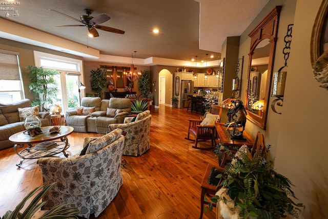 3826 Windsor Bridge Cir, Huron, OH 44839 - living area with a ceiling fan, arched walkways, a chandelier, dark wood-type flooring, and a textured ceiling