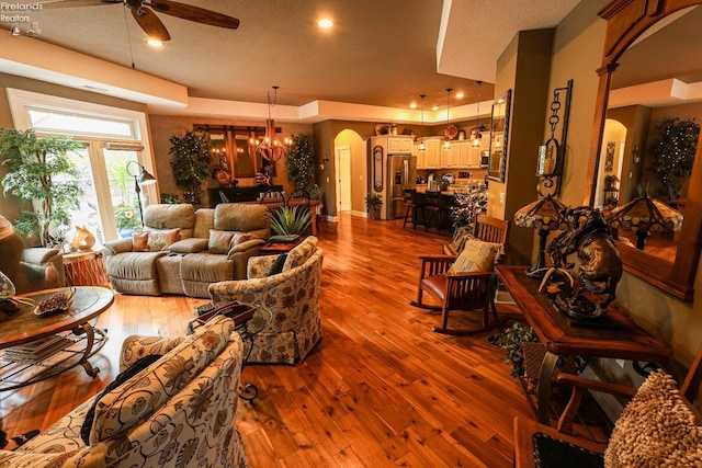 3826 Windsor Bridge Cir, Huron, OH 44839 - living area featuring arched walkways, a ceiling fan, dark wood-style flooring, and a chandelier